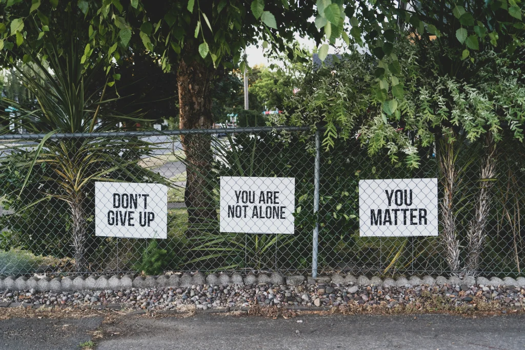 Signs saying "don't give up", "you are not alone" and "you matter"